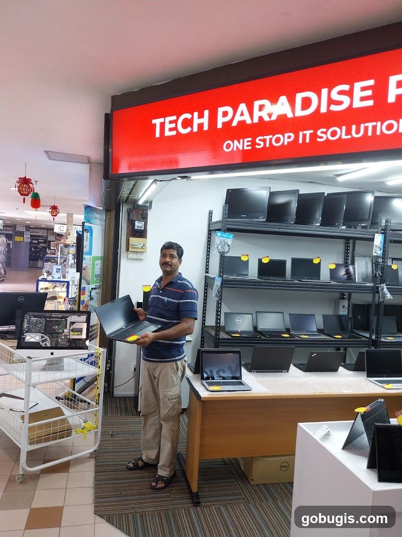 Man holding a laptop in an electronics store
