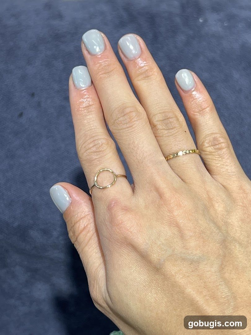 Hands with light blue nail polish and rings
