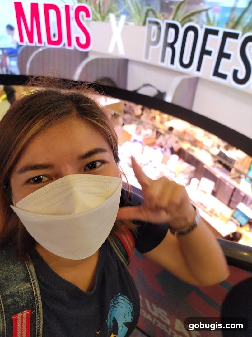 Woman posing for a selfie with a sign in the background