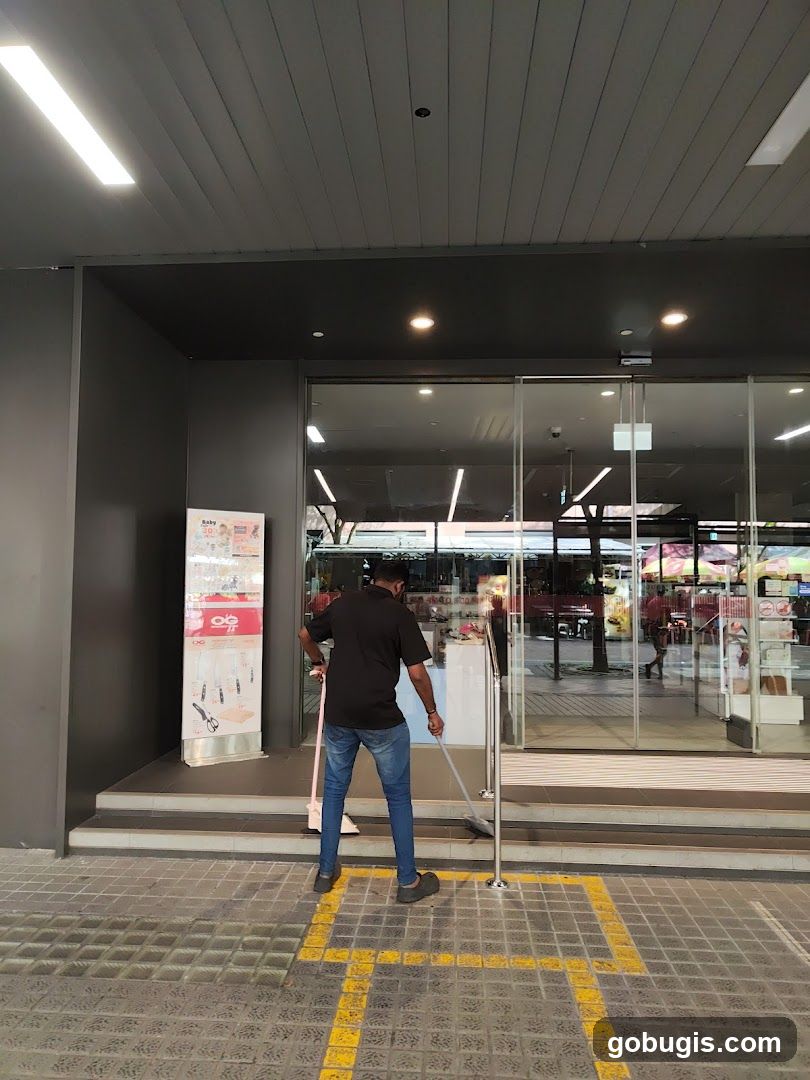 Man Sweeping Outside Store Entrance
