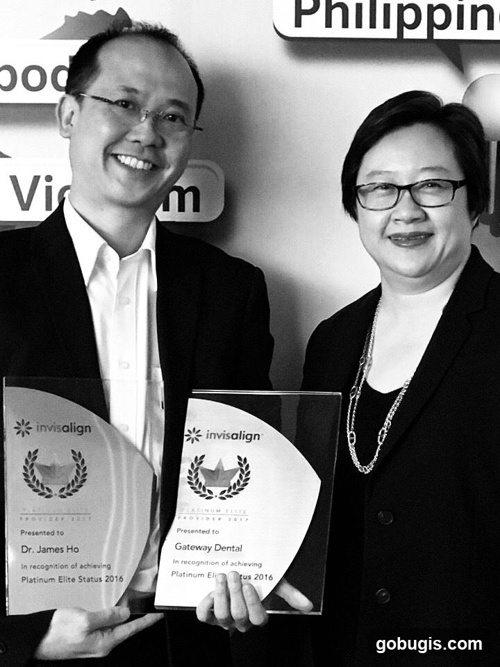 Two people holding Invisalign awards