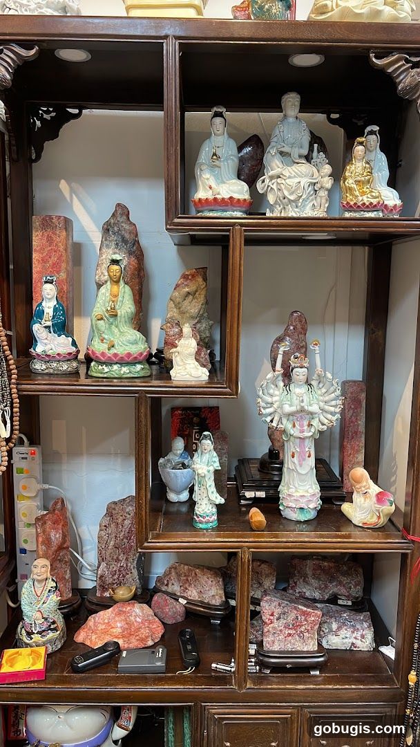 Display cabinet with Buddhist statues and stones
