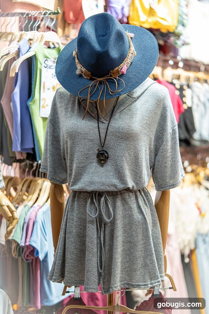 Mannequin wearing a grey dress and blue hat