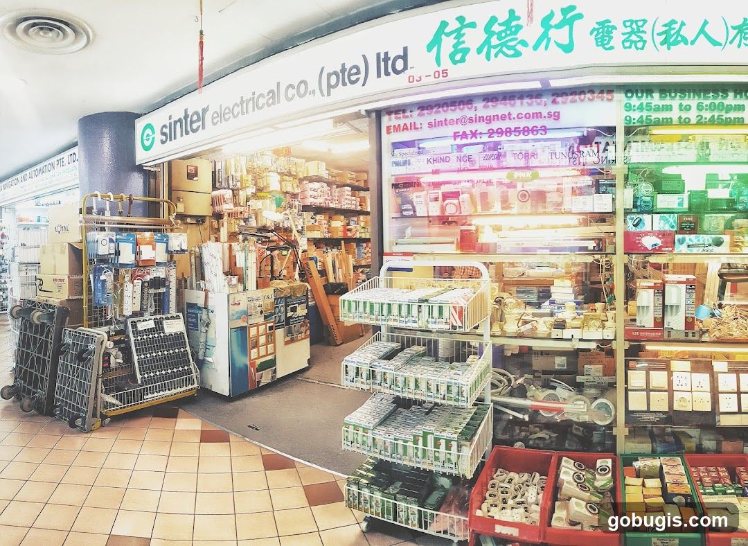 The exterior of an electrical supply store. The storefront displays various electrical components, lighting fixtures, and accessories. Signs indicate the business name and contact information.