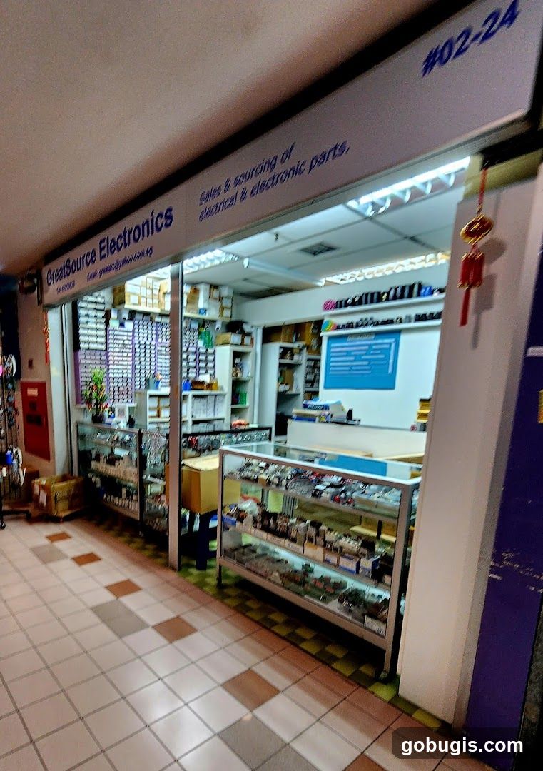 The exterior of a shop called GreatSource Electronics, specializing in sales and sourcing of electrical and electronic parts. The storefront displays various electronic components in glass display cases.