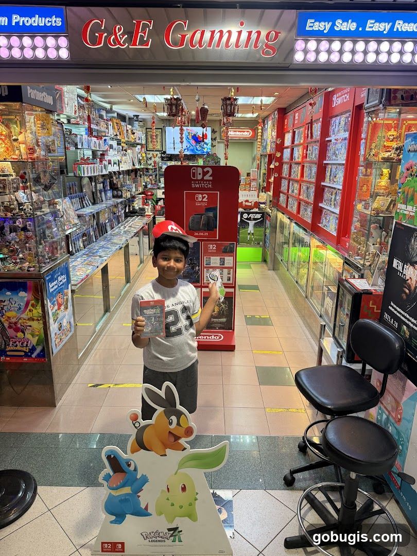 A young boy stands in front of a store called G&E Gaming, holding a video game. The store is filled with video games and gaming accessories. There are displays of Nintendo Switch games and consoles. A large cutout of Pokemon characters is in the foreground.
