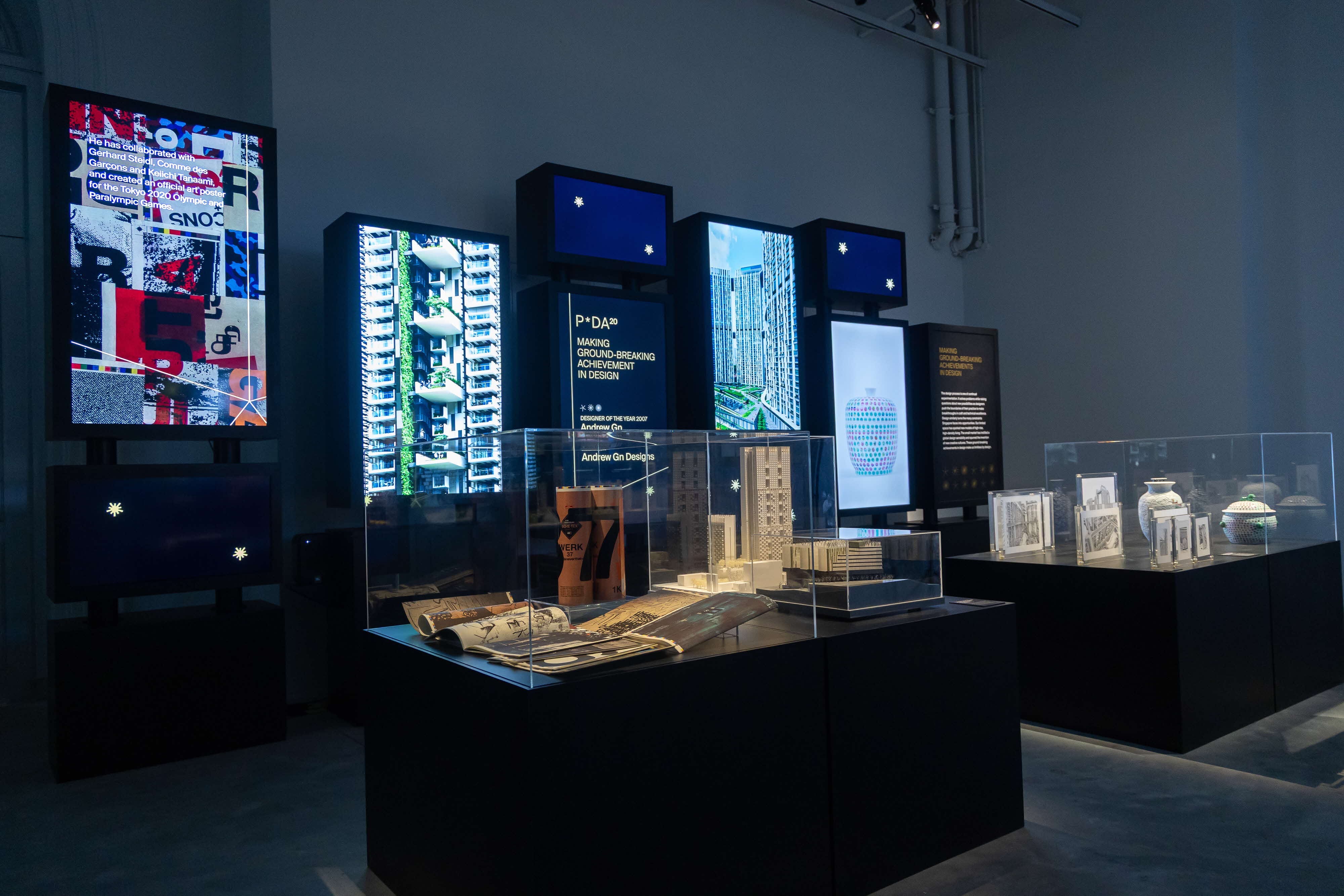 Making Groundbreaking Achievements in Design bay with WERK magazines, an architectural model, spotted ceramics and video walls of housing