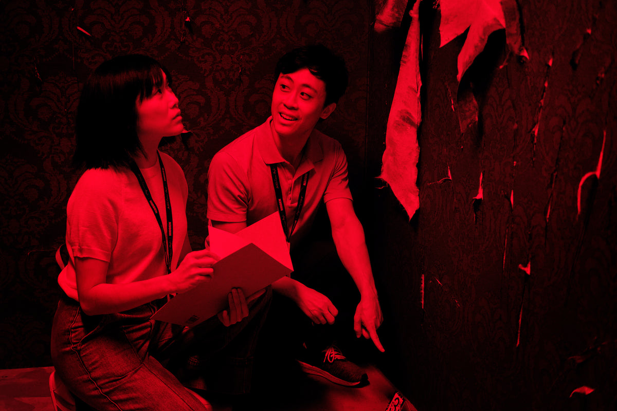 Players investigating a physical crime scene during A Study in Red in Bugis